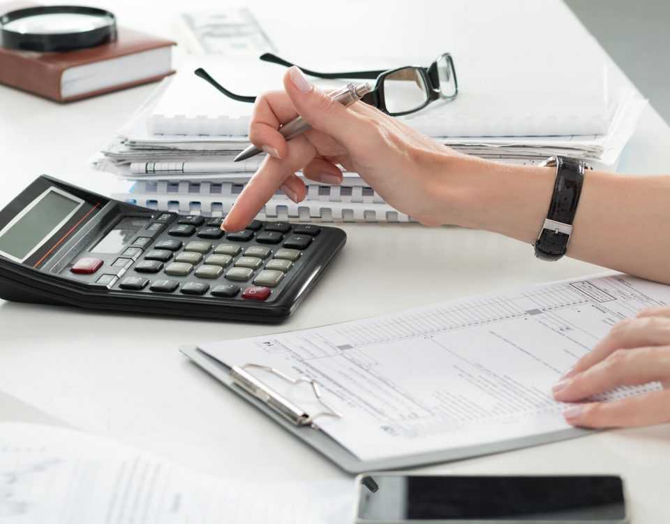Close Up Of Female Accountant Or Banker Making Calculations